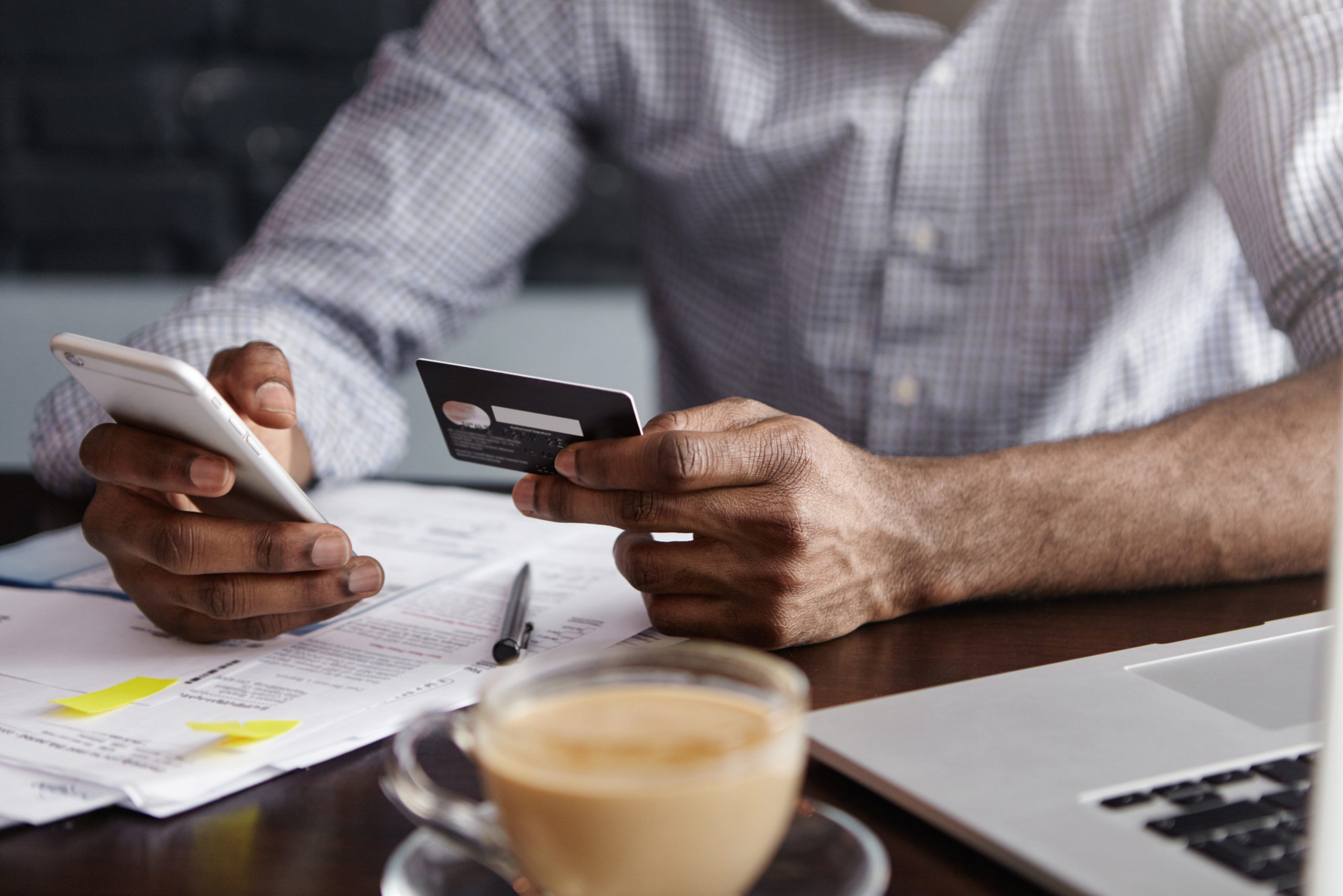 A person inputs payment information on a laptop while holding a credit card, surrounded by financial documents, a calculator, and a map of the United States. The setting reflects data analysis and online transactions, symbolizing the influence of revolutionary credit on the US credit card market and evolving consumer financial behavior.