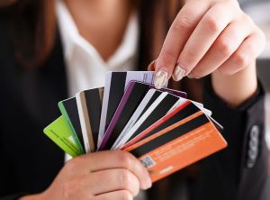 Close-up of a woman holding several different cards in her hands, representing the variety of payment cards available for financial management.
